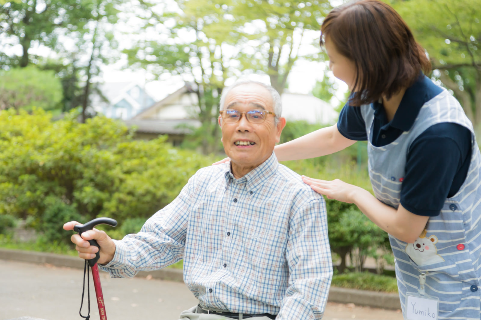 公園で笑顔のおじいさんと介護スタッフ